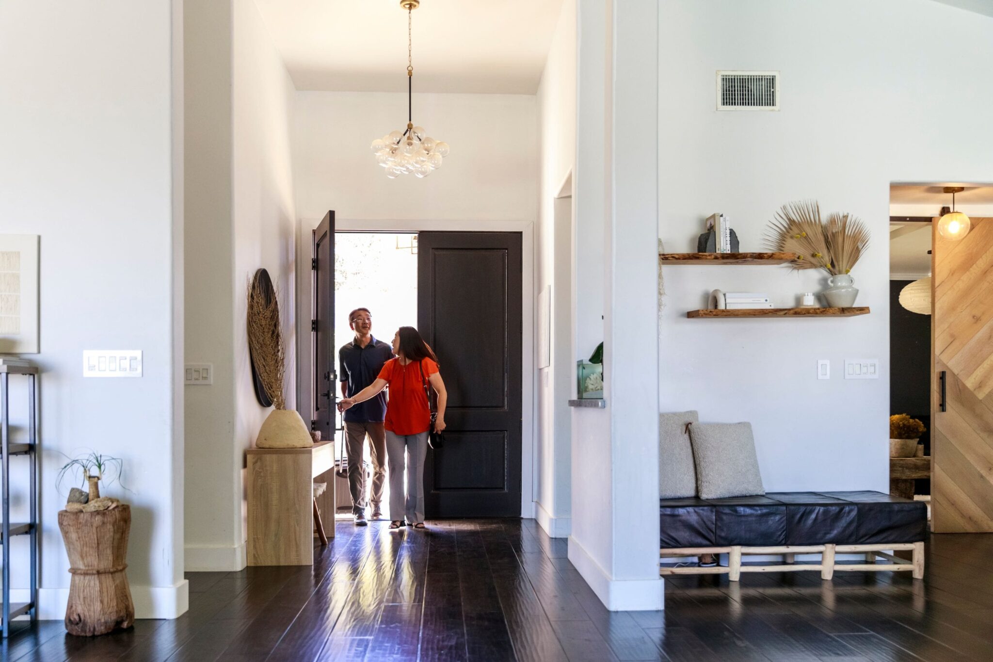 a couple with suitcases walking into a vacation rental home