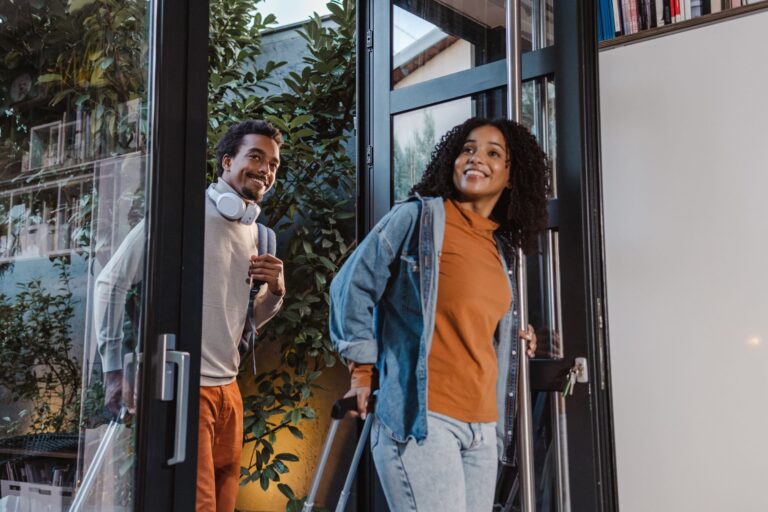 a couple pulling suitcases as they walk into their vacation rental home