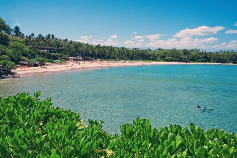 landscape view of Mauna Kea beach under a blue sky with a few clouds