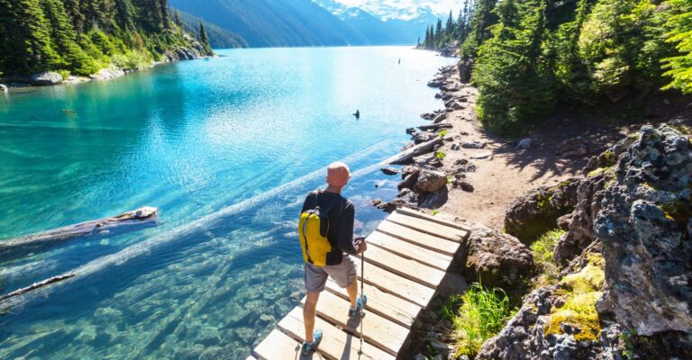 person hiking on a trail right alongside the water at Lake Tahoe
