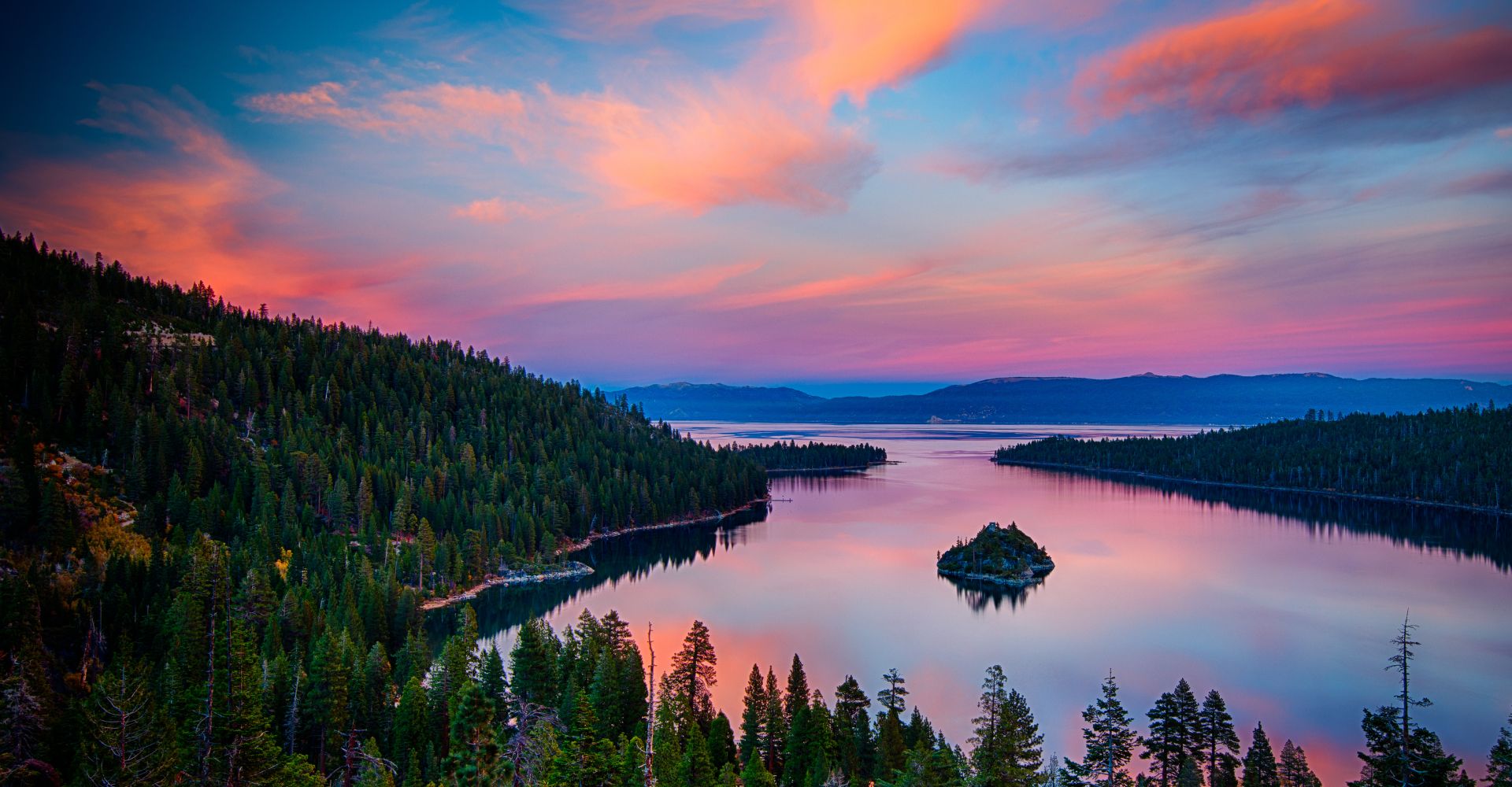 A stunning sunset casts vibrant colors over Lake Tahoe, reflecting beautifully on the calm water's surface