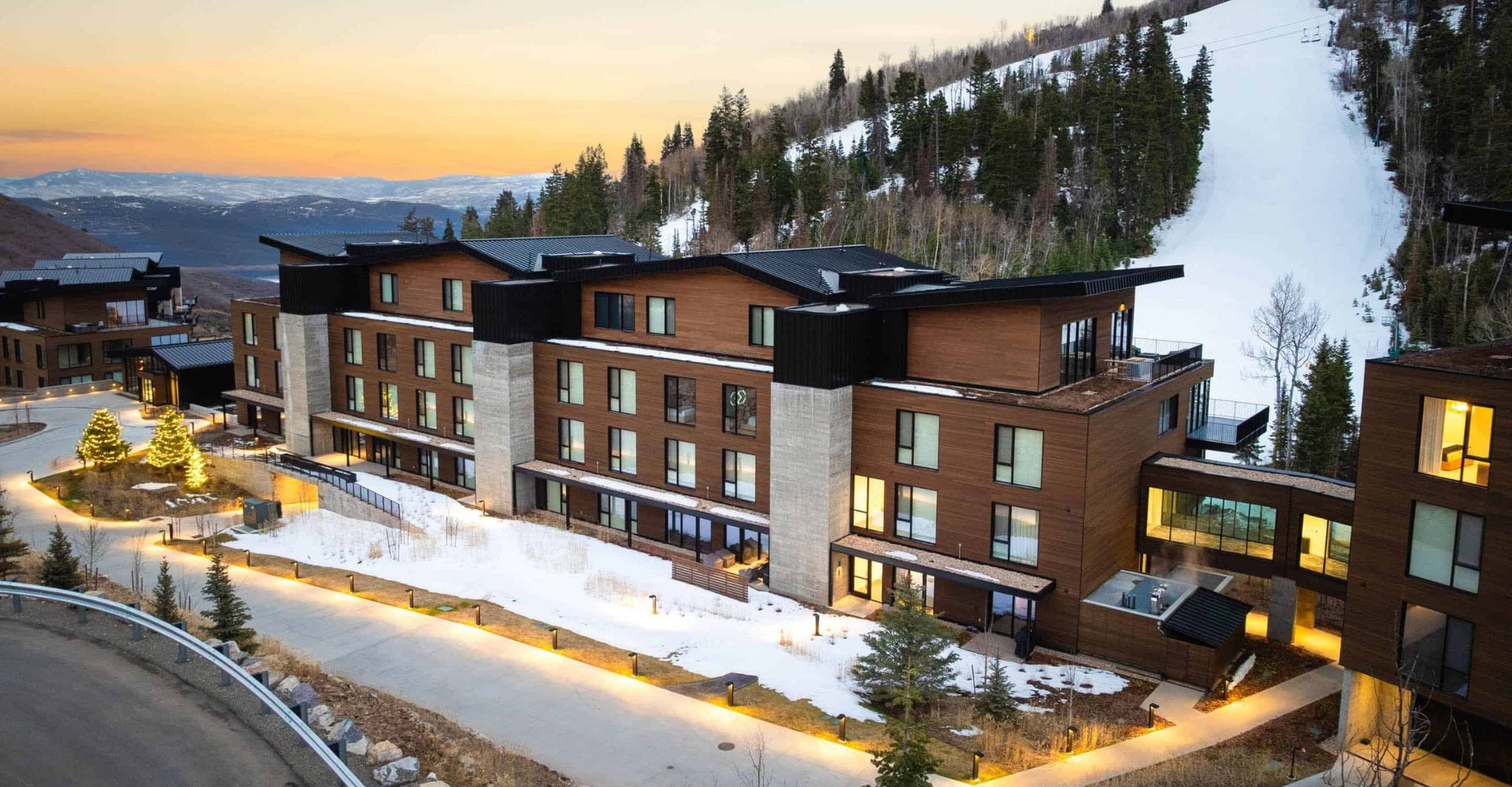 A scenic mountain resort nestled on the slopes, surrounded by lush greenery and stunning views of the peaks.