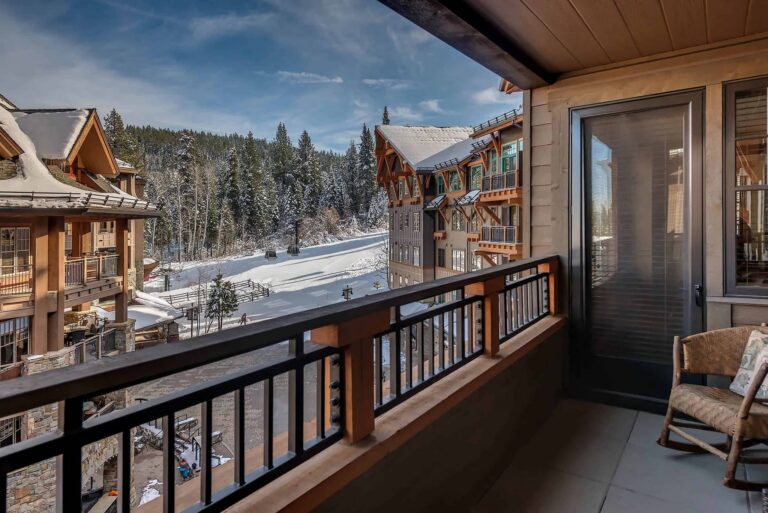 A cozy balcony with a chair overlooking stunning mountains in the background.